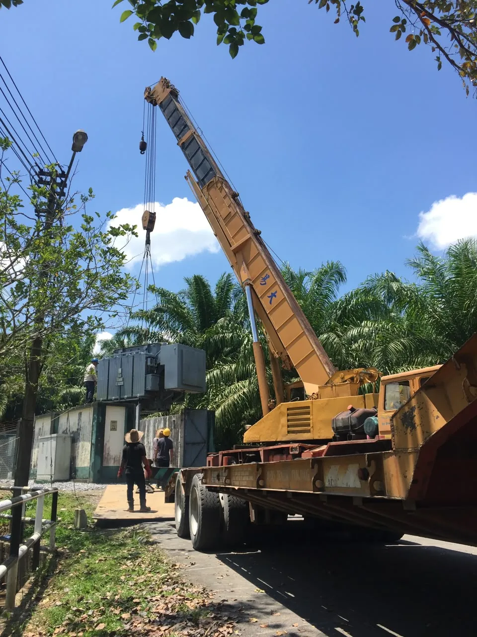 Yellow mobile crane lifting industrial equipment